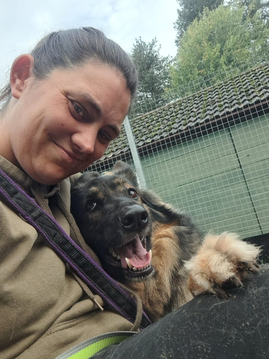 Danielle sharing a happy cuddle with a shepherd type dog