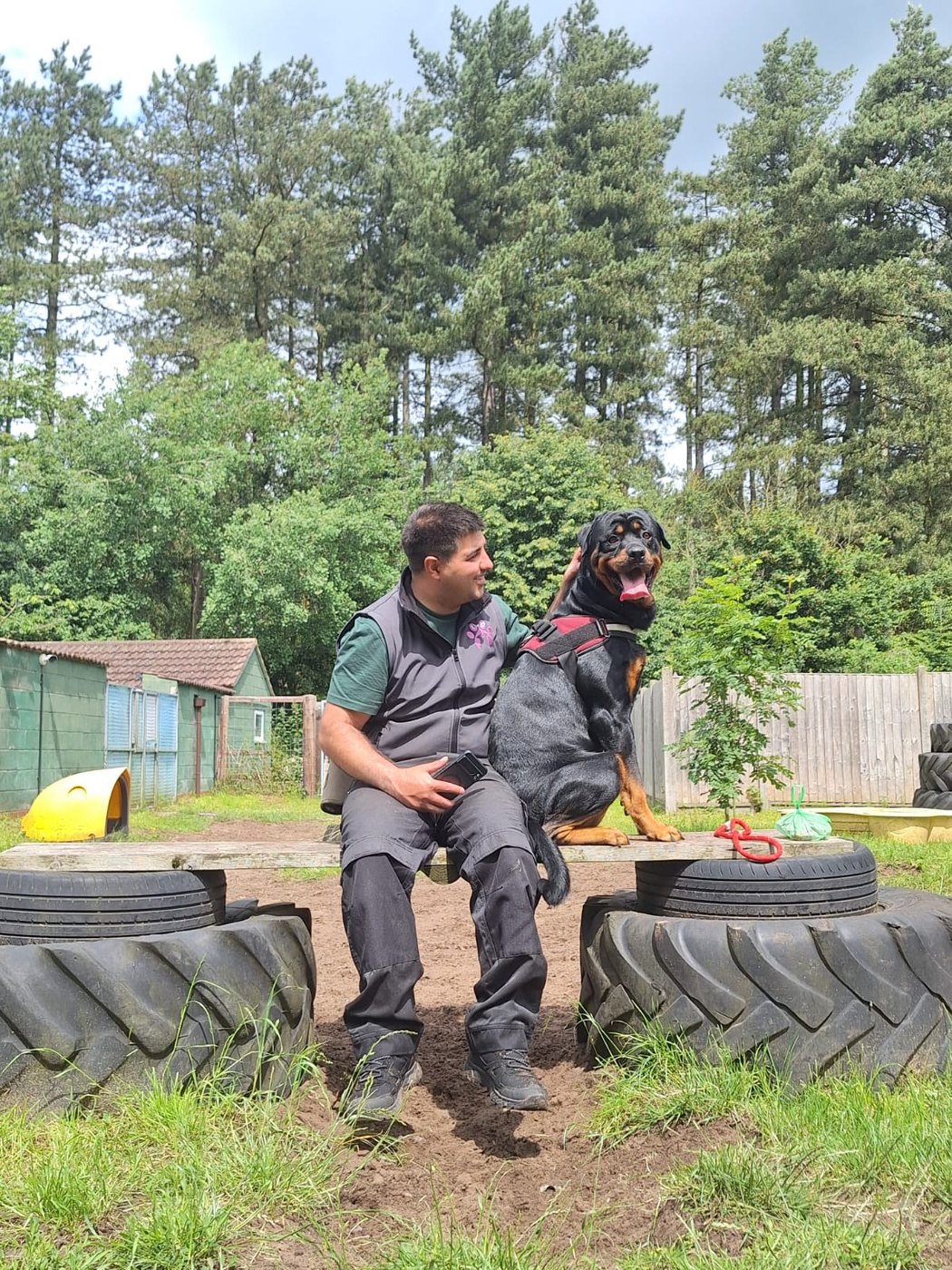 Marcus sitting with a Rottweiler in a secure exercise area